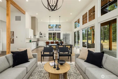 a living room with furniture a dining table and a chandelier