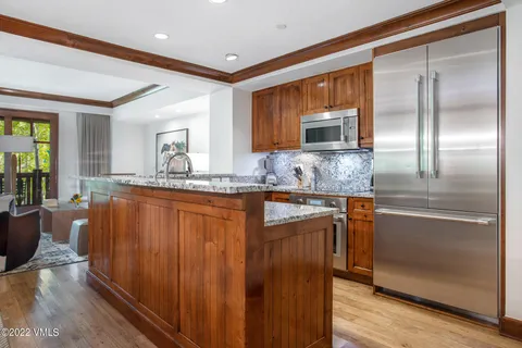 a bathroom with stainless steel appliances granite countertop a refrigerator and a sink