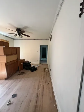 a view of a livingroom with a furniture wooden floor and a ceiling fan