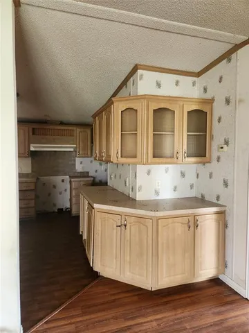 a view of a kitchen with wooden floor and a window