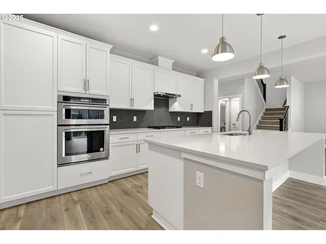 a kitchen with stainless steel appliances a sink a stove a microwave and cabinets