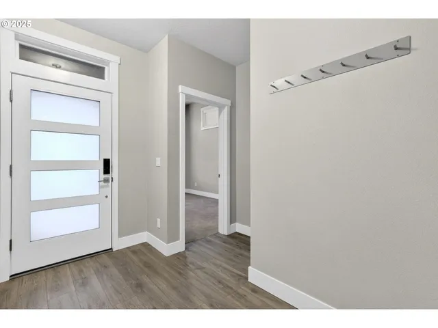 a view of an empty room with wooden floor and closet