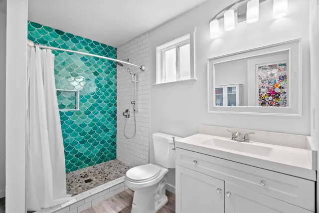 a view of a house with sitting area and covered with tall trees