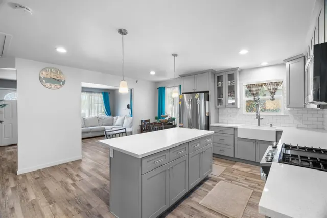 a large white kitchen with a large counter top appliances and cabinets
