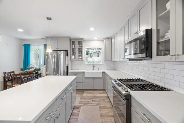 a kitchen that has a stove a sink and a refrigerator
