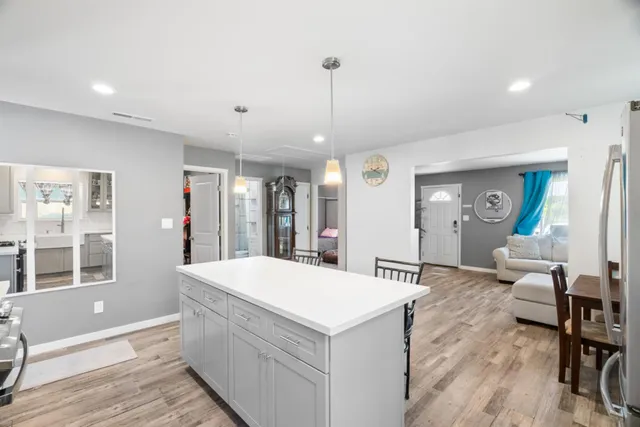 a room with kitchen island a wooden floor and a chandelier