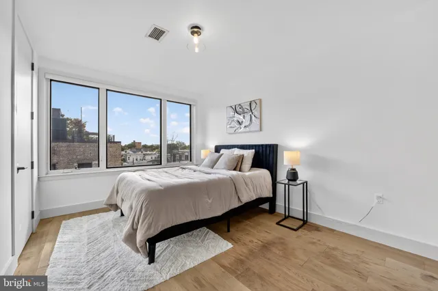 a bedroom with a bed and a large window