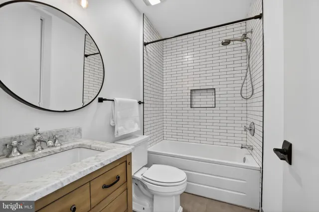 a bathroom with a granite countertop sink a toilet and a mirror