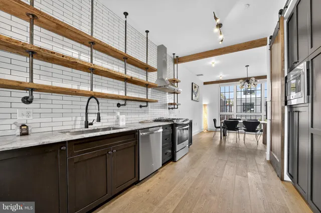a kitchen with stainless steel appliances granite countertop a sink a oven and wooden floors