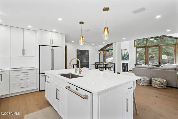a kitchen that has a lot of white cabinets and stainless steel appliances