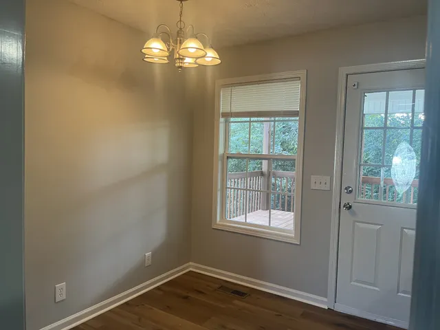a view of a livingroom with wooden floor and windows
