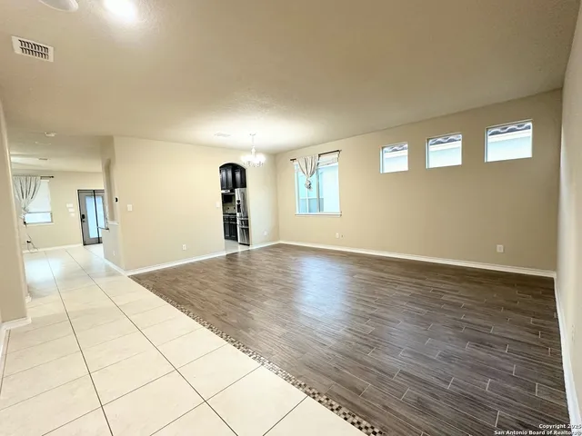 a view of a hallway with wooden floor and a living room