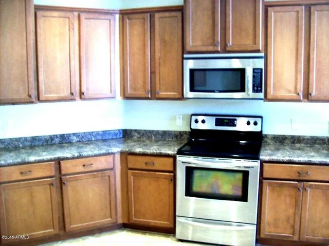 a kitchen with granite countertop white cabinets and black appliances