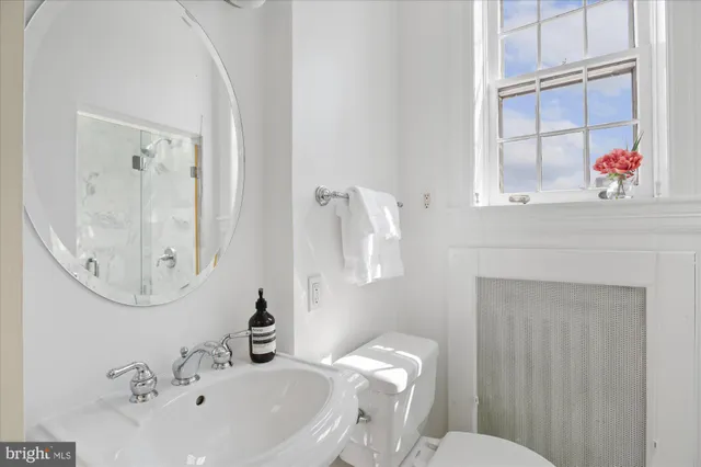 a bathroom with a sink mirror and toilet