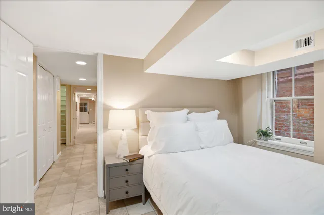 a large white bedroom with a large bed and a window