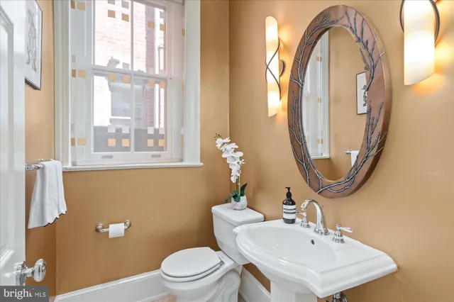 a bathroom with a toilet a sink and a mirror