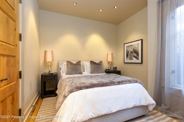 a spacious bedroom with a bed and a painting on the wall