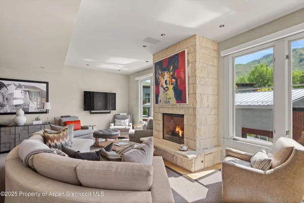 a living room with furniture a flat screen tv and a fireplace