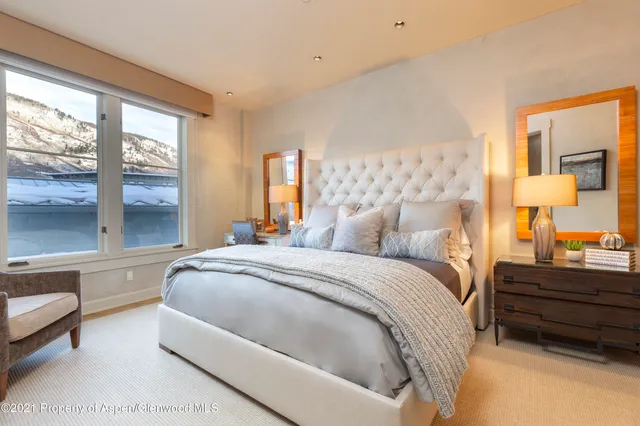 a bedroom with a bed and a large window