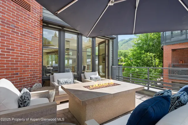 a view of a patio with a table and chairs under an umbrella