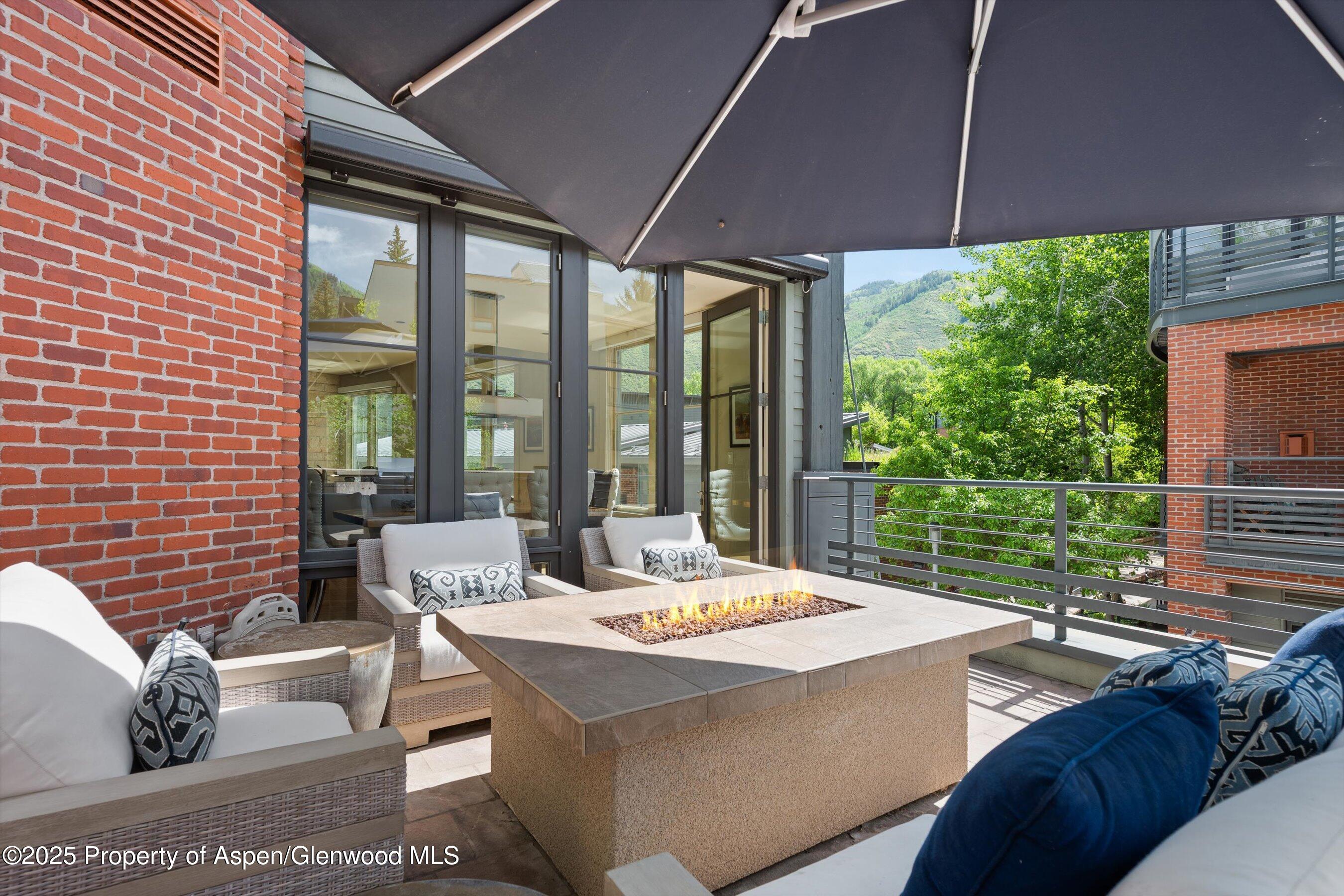 101 Founders Place, Unit 202 Aspen, CO 81611 - Photo 24 of 26 a view of a patio with a table and chairs under an umbrella
