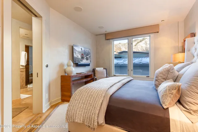 a bedroom with a bed and a large window