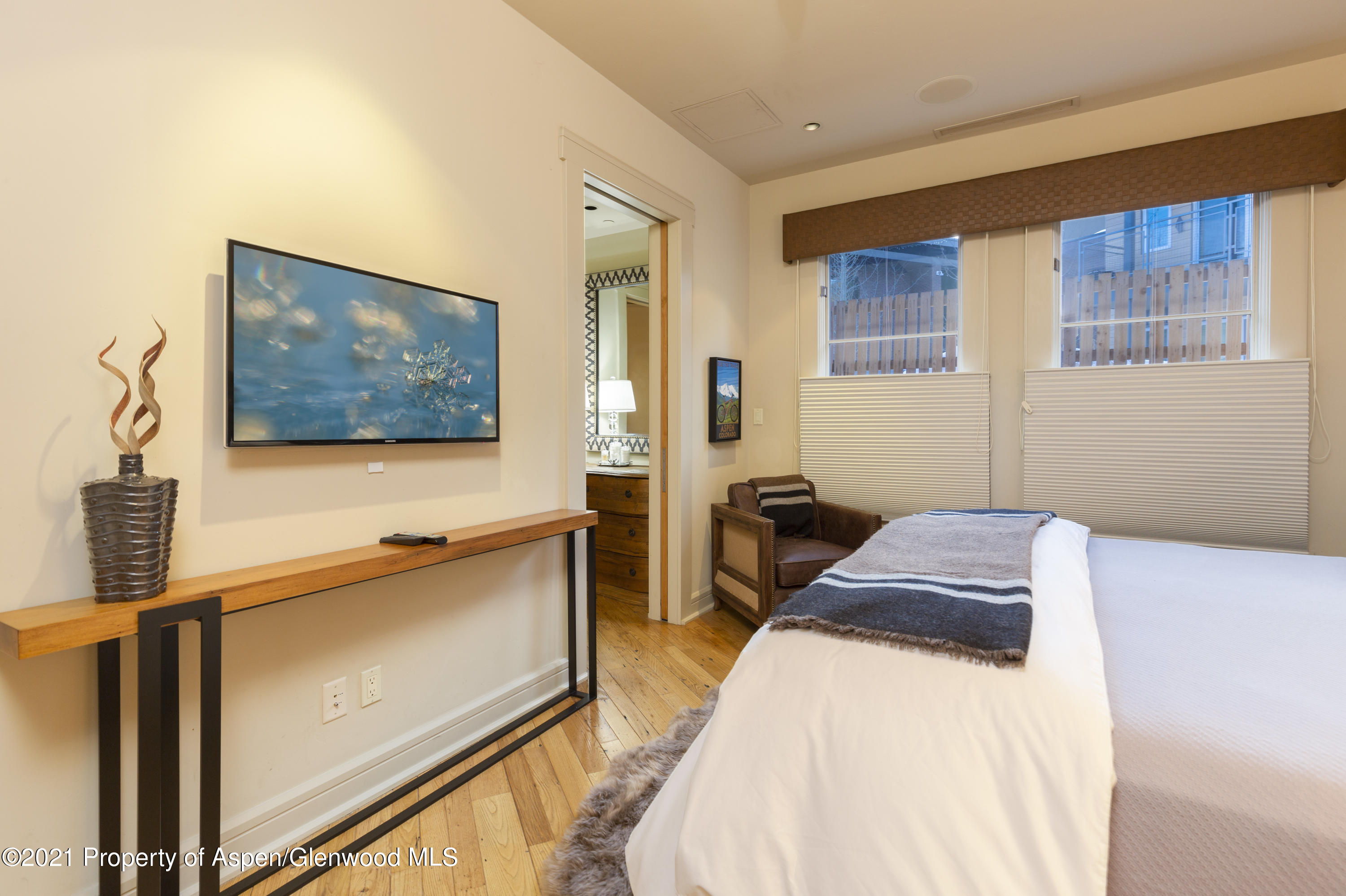 101 Founders Place, Unit 202 Aspen, CO 81611 - Photo 6 of 26 a bedroom with a bed and a flat screen tv