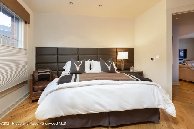 a large bed sitting in a bedroom next to a window