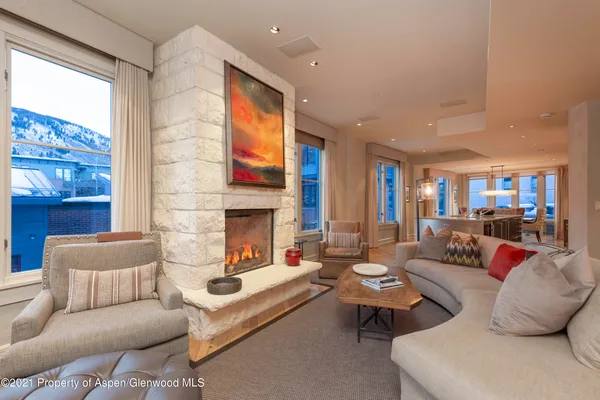a living room with furniture fireplace and a large window