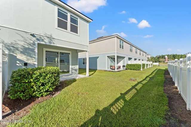 an aerial view of residential houses with outdoor space and trees all around