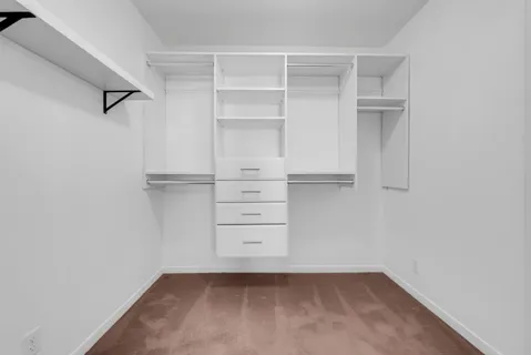 a view of empty room with wooden floor and window