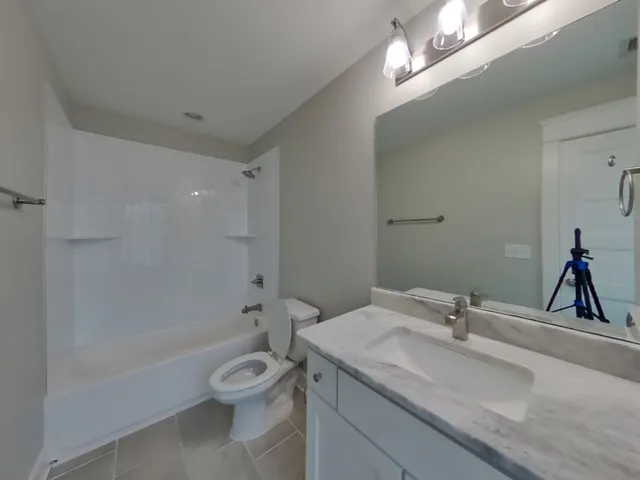 a bathroom with a granite countertop toilet a sink and a bathtub