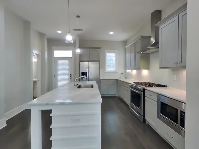a kitchen with sink stove and refrigerator