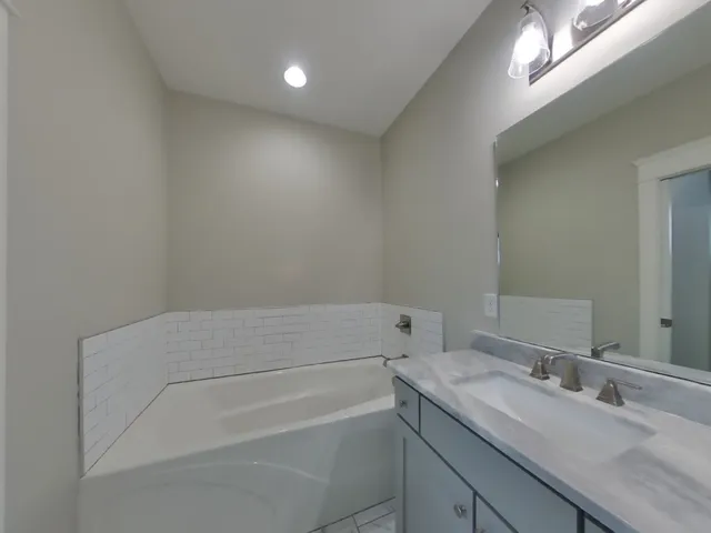 a bathroom with a granite countertop sink a toilet and a bathtub