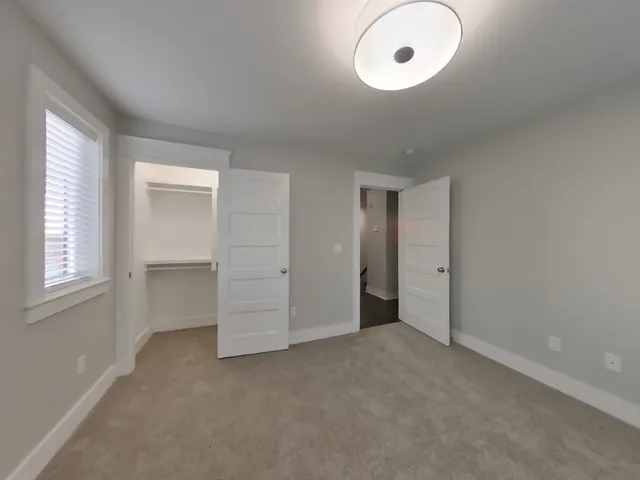 an empty room with windows and closet