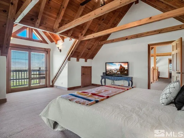 a bedroom with a bed a flat screen tv and balcony view
