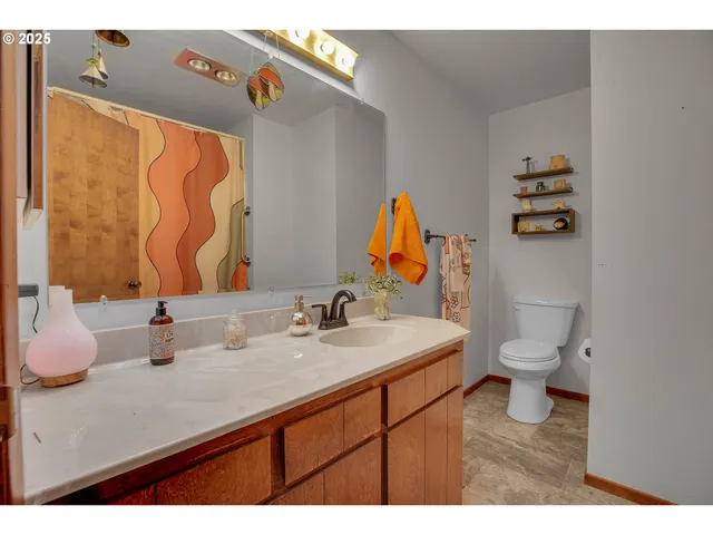 a bathroom with a sink vanity mirror and toilet