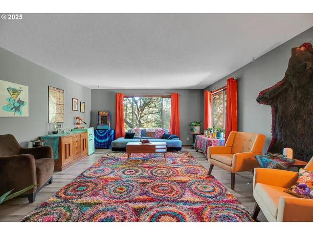 a living room with furniture a rug a fireplace and a window