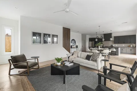 a living room with furniture wooden floor and a kitchen view