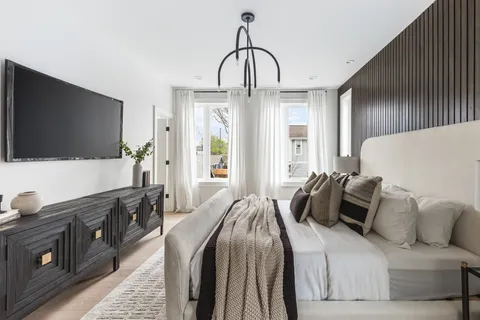 a bedroom with a bed and a flat screen tv