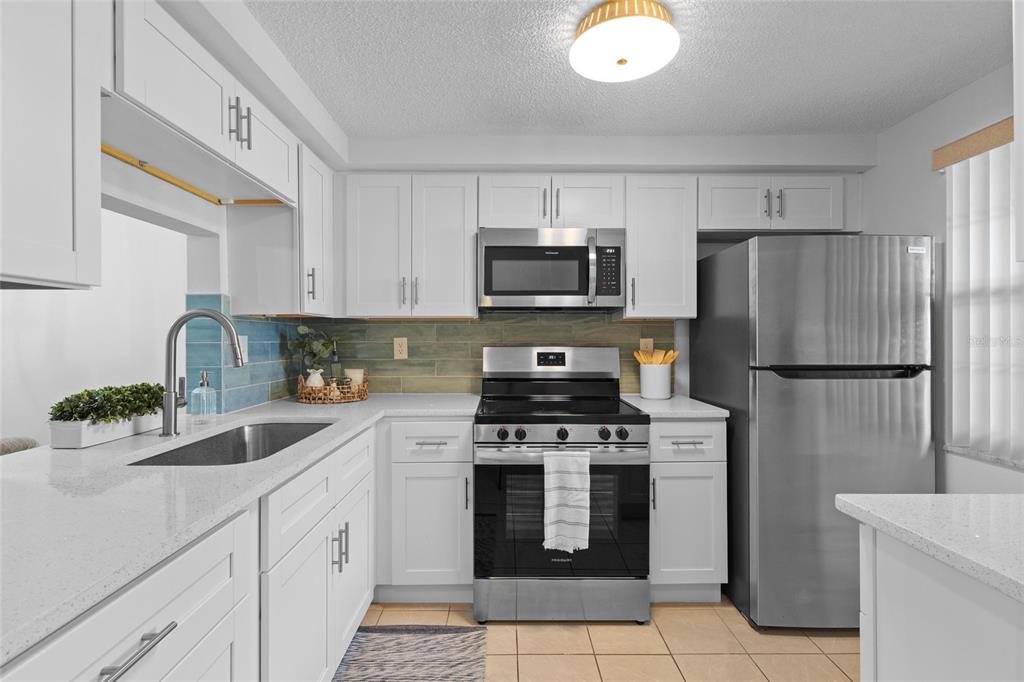 4409 Summersun Drive New Port Richey, FL 34652 - Photo 3 of 23 a kitchen with refrigerator a sink a stove and cabinets