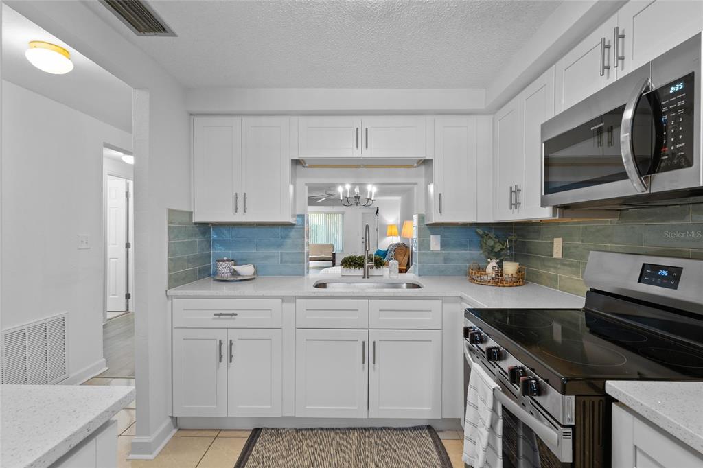 4409 Summersun Drive New Port Richey, FL 34652 - Photo 5 of 23 a kitchen with stainless steel appliances granite countertop a sink and a stove