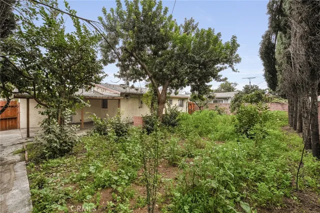 a view of a house with a yard and tree s