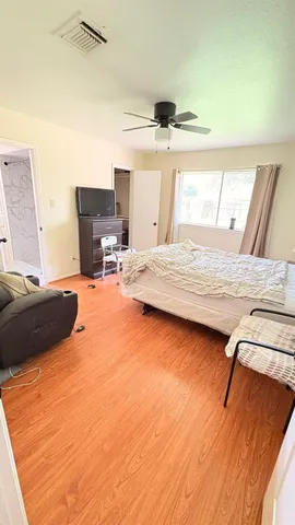 a bedroom with a bed and wooden floor