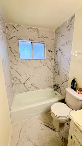 a bathroom with a toilet and a shower