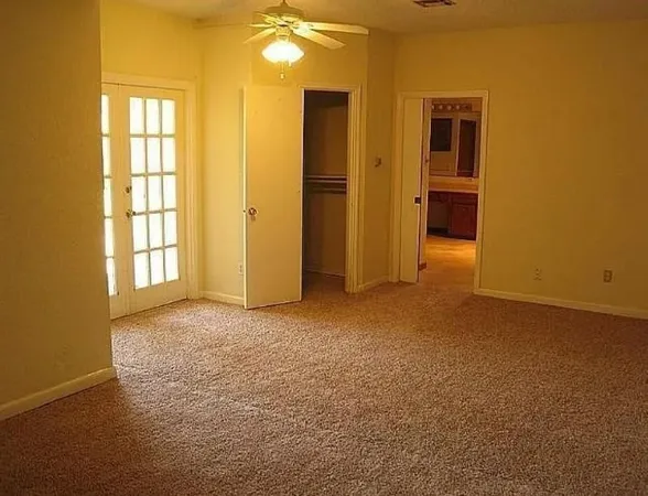 an empty room with windows and closet