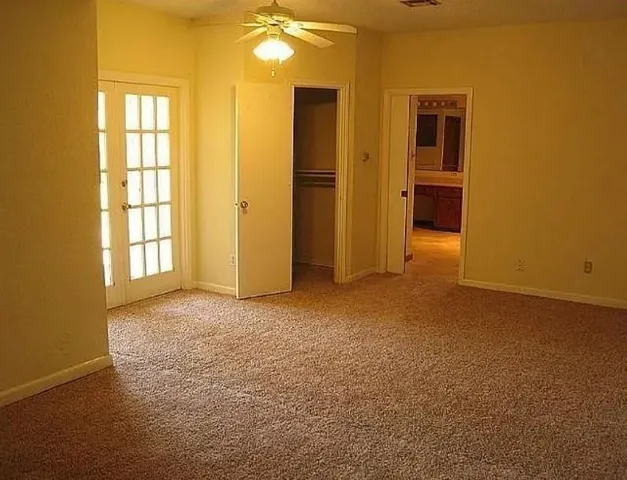 an empty room with windows and closet