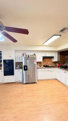 a large kitchen with stainless steel appliances granite countertop a large counter top and a stove