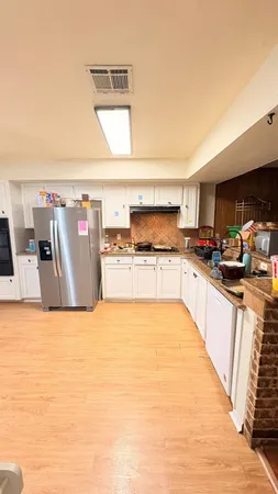 a large kitchen with stainless steel appliances kitchen island a large counter top and a stove