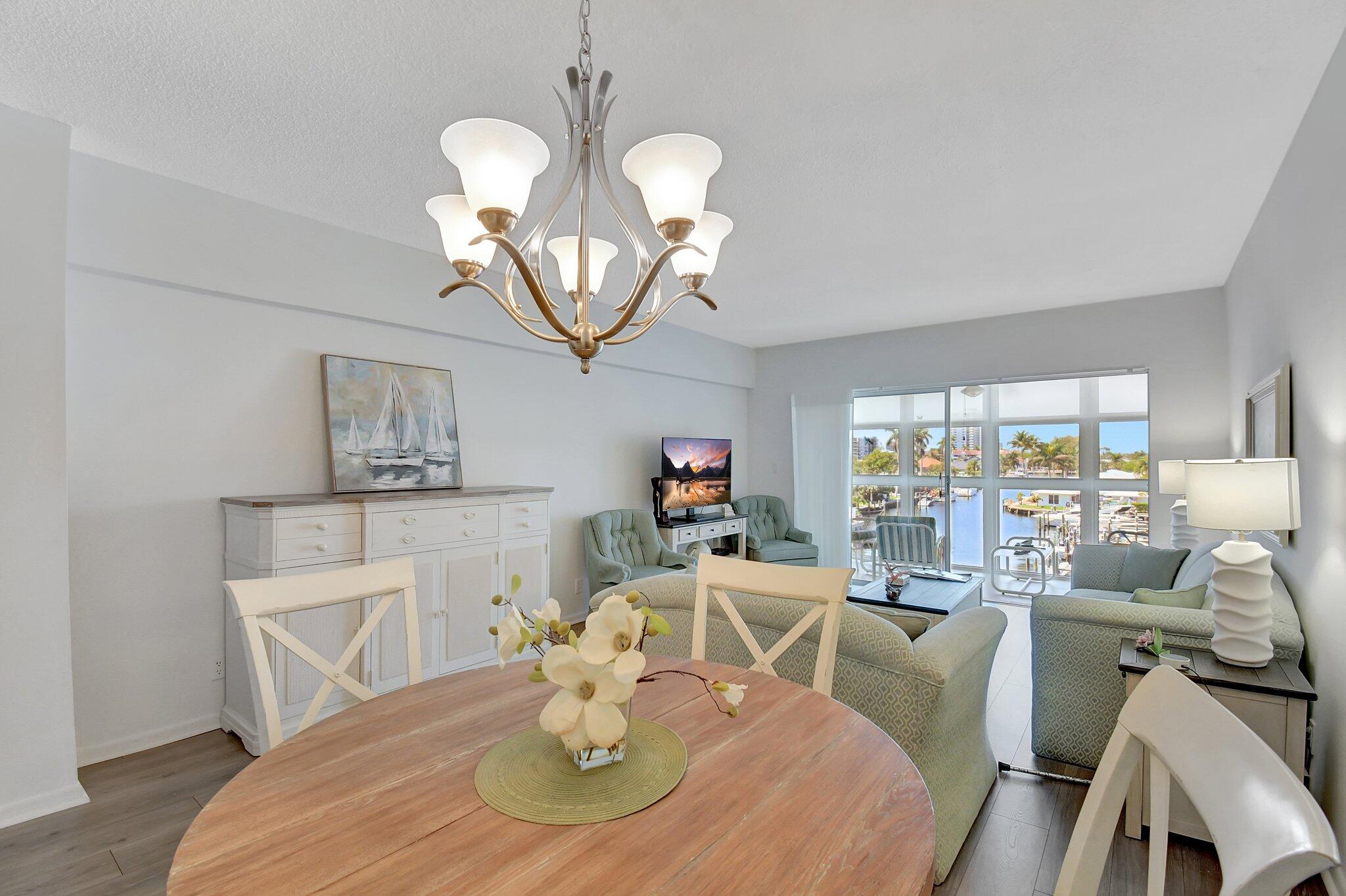 1481 South Ocean Boulevard, Unit 413A Lauderdale-by-the-Sea, FL 33062 - Photo 13 of 48 a view of a dining room with furniture a chandelier and wooden floor
